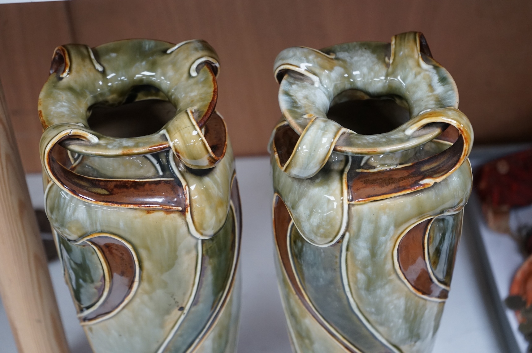 A pair of Royal Doulton, Art Nouveau vases by Frank Butler, incised and impressed marks to the bases, 37cm high